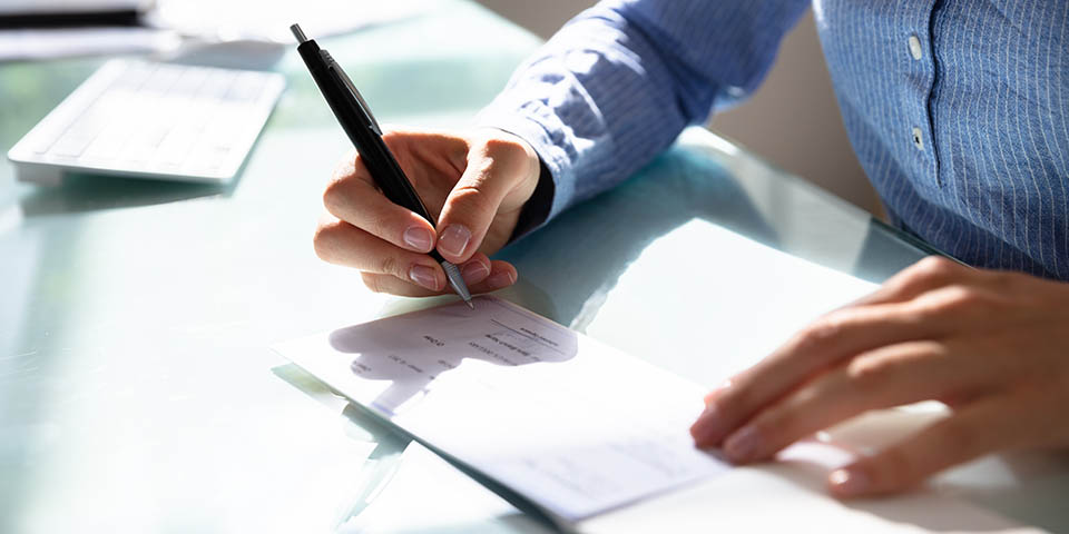 woman signing a paper check